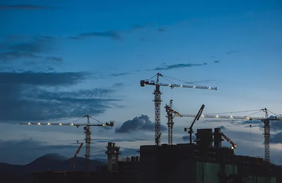 Kvällbild på byggkranar, blå.